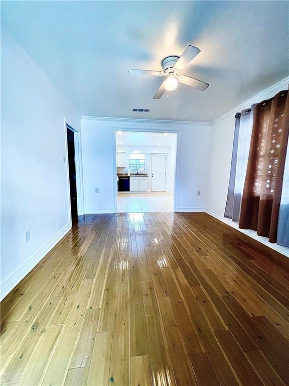 unfurnished living room featuring wood-type flooring and ceiling fan