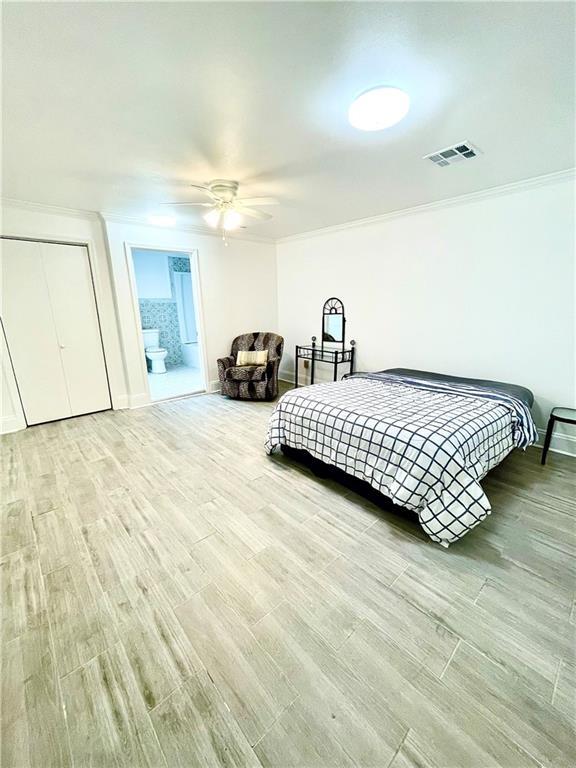 bedroom with ensuite bath, ceiling fan, ornamental molding, and light wood-type flooring