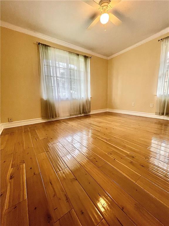 unfurnished room featuring hardwood / wood-style floors, ceiling fan, and ornamental molding