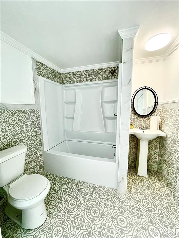 bathroom featuring tile patterned floors, crown molding, tub / shower combination, and toilet