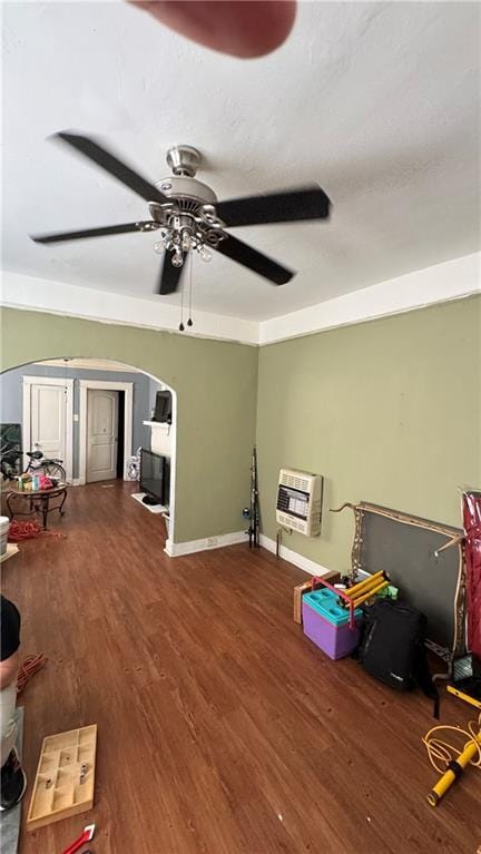 interior space featuring ceiling fan, wood-type flooring, and heating unit