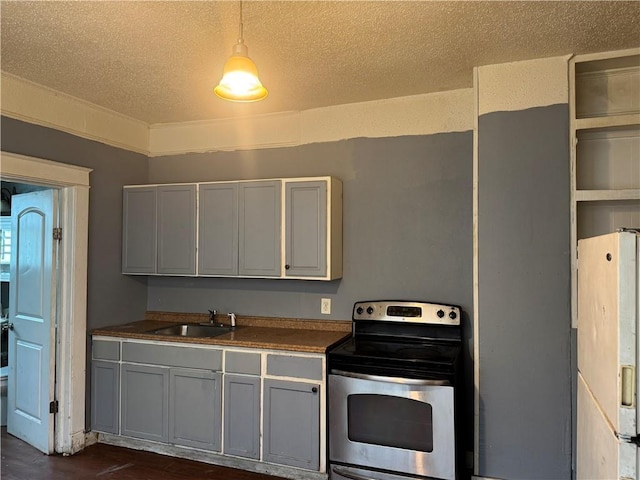 kitchen with sink, white fridge with ice dispenser, a textured ceiling, stainless steel electric range oven, and decorative light fixtures