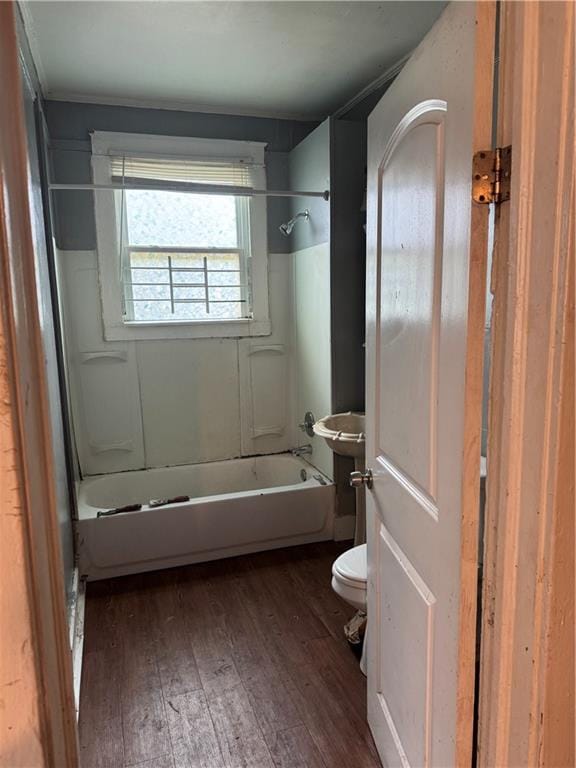 bathroom with wood-type flooring,  shower combination, and toilet