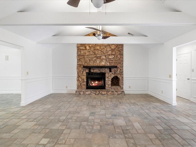 unfurnished living room with vaulted ceiling with beams and a stone fireplace