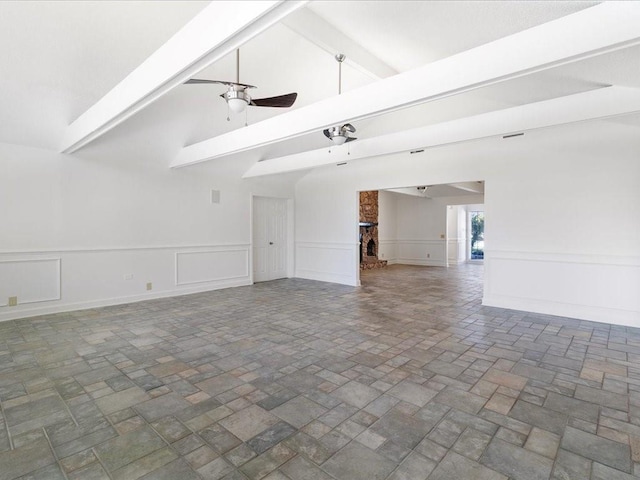 unfurnished living room with beamed ceiling, ceiling fan, high vaulted ceiling, and a brick fireplace