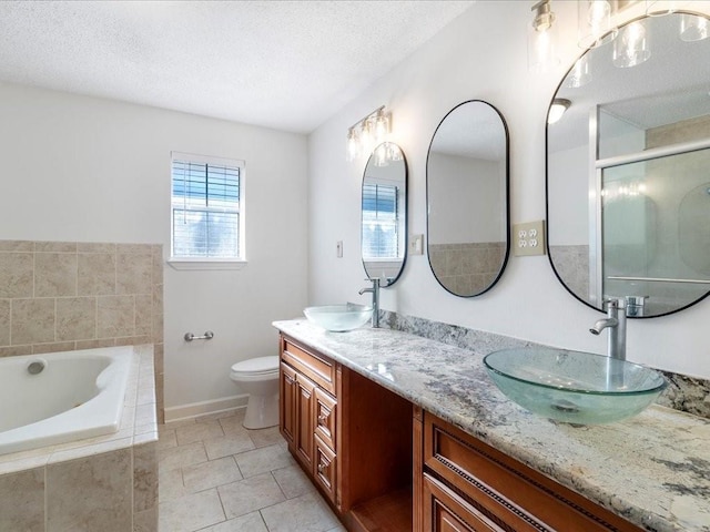 full bathroom featuring tile patterned floors, vanity, a textured ceiling, and toilet