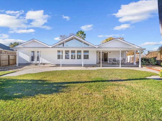 rear view of house featuring a yard, a patio, and french doors