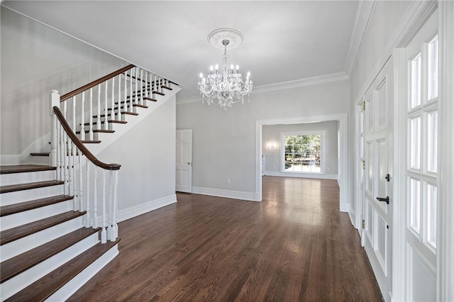 foyer entrance featuring dark hardwood / wood-style flooring, crown molding, and an inviting chandelier