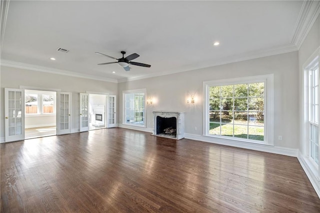 unfurnished living room featuring french doors, ornamental molding, ceiling fan, a fireplace, and dark hardwood / wood-style floors