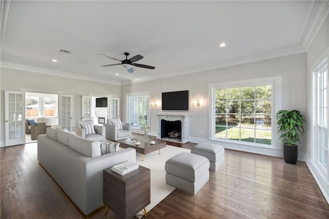 living room with a high end fireplace, french doors, ceiling fan, dark hardwood / wood-style floors, and ornamental molding