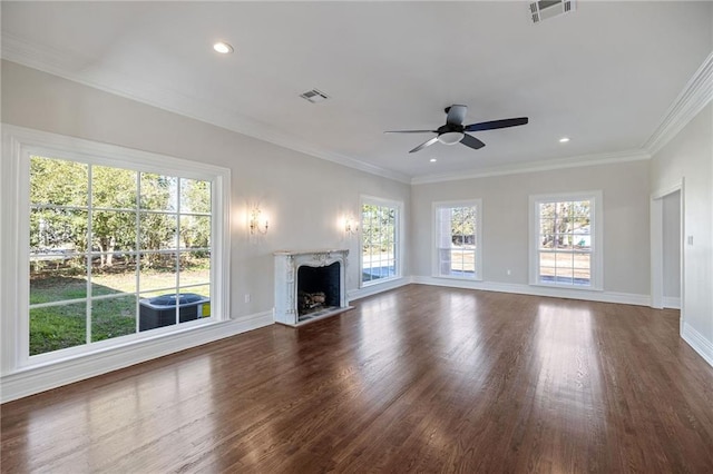 unfurnished living room featuring ceiling fan, dark hardwood / wood-style floors, a premium fireplace, and ornamental molding