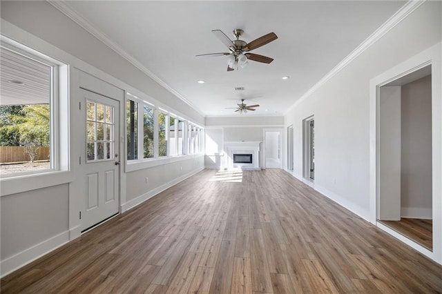 unfurnished living room featuring wood-type flooring, ceiling fan, and ornamental molding