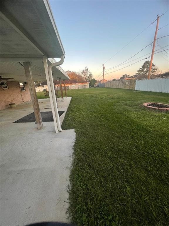 yard at dusk with a patio and an outdoor fire pit