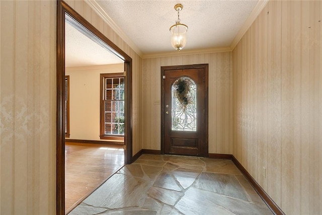 entryway with wooden walls, a textured ceiling, and ornamental molding