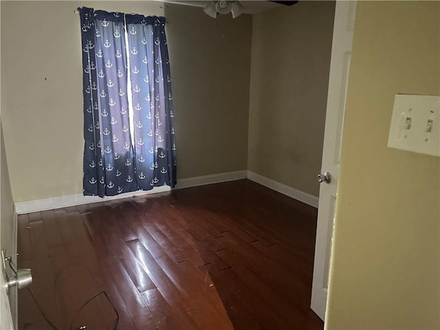 empty room with ceiling fan and dark wood-type flooring