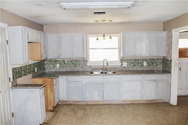 kitchen featuring backsplash, white cabinetry, and sink