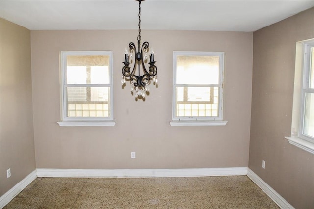 unfurnished dining area featuring a chandelier and plenty of natural light