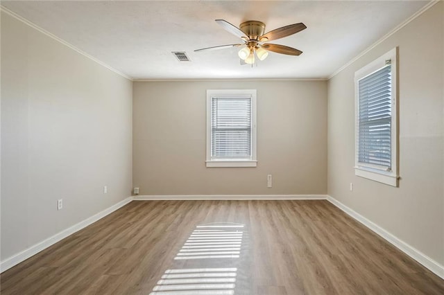 unfurnished room featuring wood-type flooring, crown molding, and a wealth of natural light