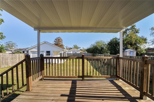 wooden terrace featuring an outbuilding, a yard, and a garage