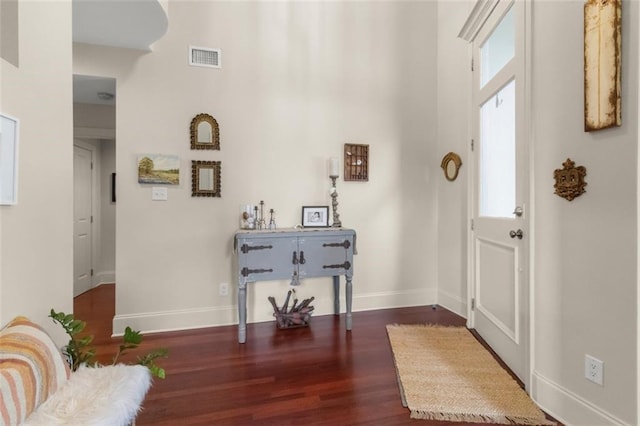 entryway with a healthy amount of sunlight and dark hardwood / wood-style flooring