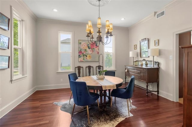 dining area featuring dark wood-type flooring, crown molding, and an inviting chandelier