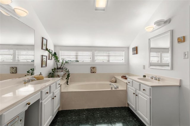 bathroom featuring vanity, lofted ceiling, and a tub