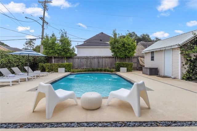 view of swimming pool featuring pool water feature, a patio area, and an outbuilding