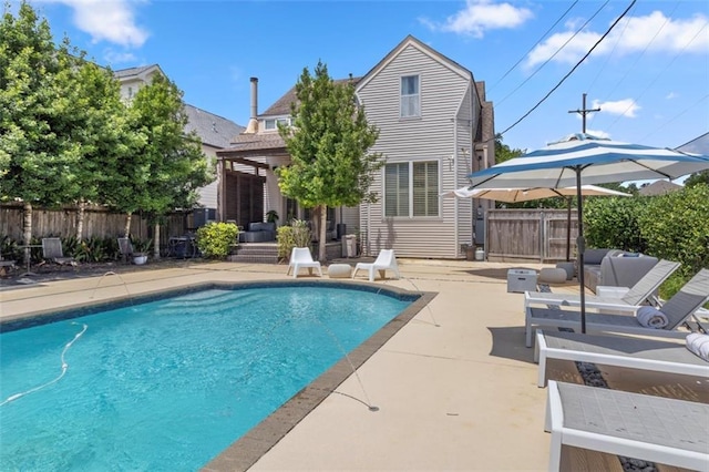 back of house with a fenced in pool and a patio