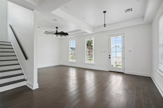 unfurnished living room featuring a tray ceiling, ceiling fan, and dark wood-type flooring