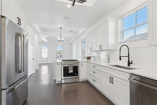 kitchen featuring hanging light fixtures, white cabinetry, sink, and appliances with stainless steel finishes