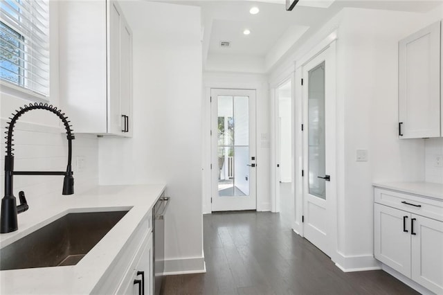 kitchen with sink, white cabinets, stainless steel dishwasher, and dark hardwood / wood-style floors