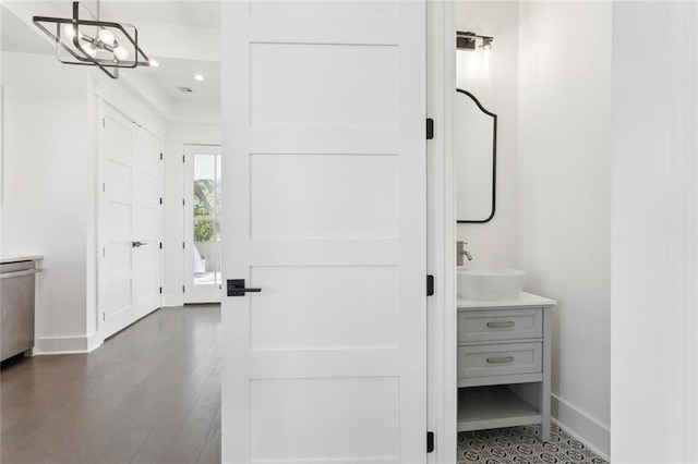 bathroom featuring hardwood / wood-style flooring, vanity, and a notable chandelier