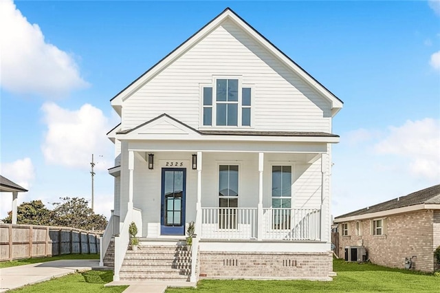 view of front of house with covered porch, central air condition unit, and a front yard