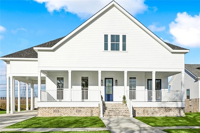 view of front facade featuring a front lawn, covered porch, and a carport