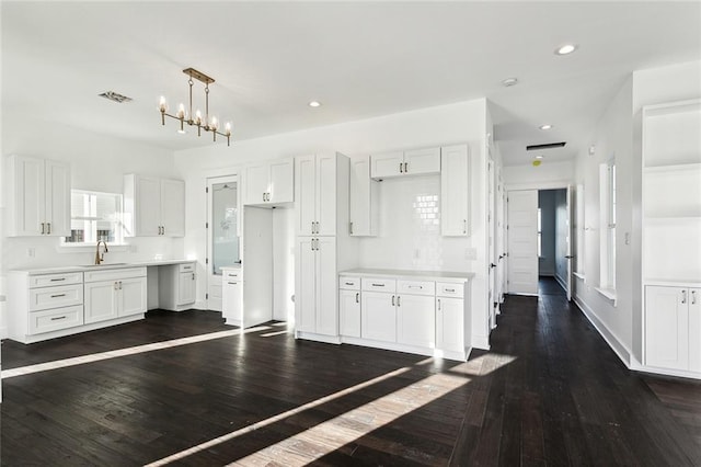 kitchen featuring dark hardwood / wood-style flooring, white cabinetry, and sink