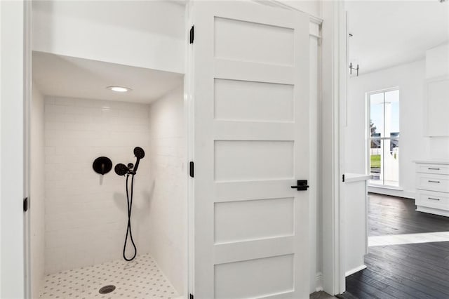 bathroom featuring wood-type flooring and tiled shower