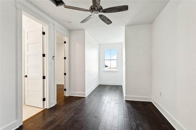 empty room with ceiling fan and dark hardwood / wood-style flooring