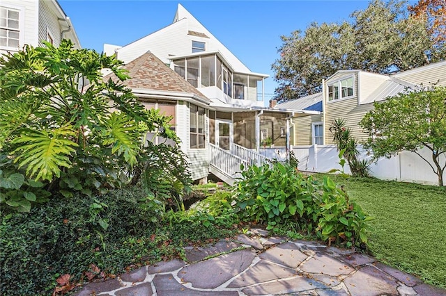 rear view of house featuring a sunroom