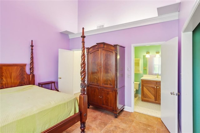 bedroom with ensuite bath, crown molding, and sink