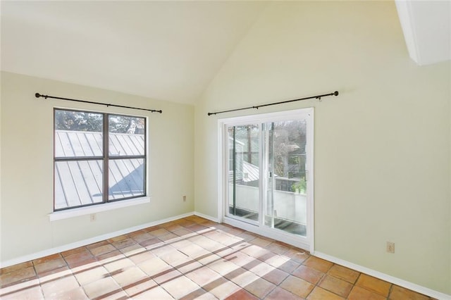 tiled empty room with a healthy amount of sunlight and vaulted ceiling