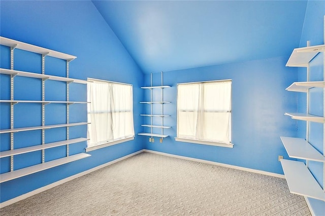 unfurnished room with carpet flooring, a wealth of natural light, and lofted ceiling