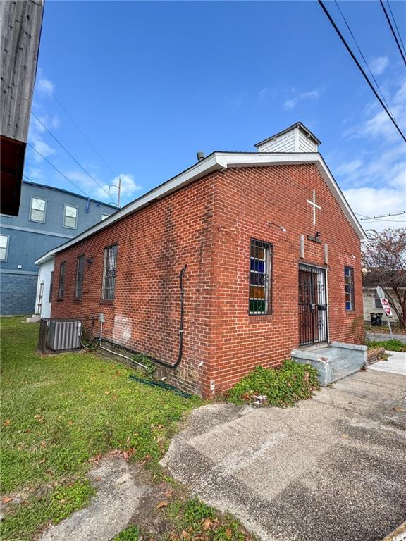 view of side of property with a lawn and central air condition unit