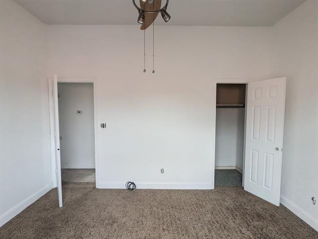 unfurnished bedroom featuring dark colored carpet