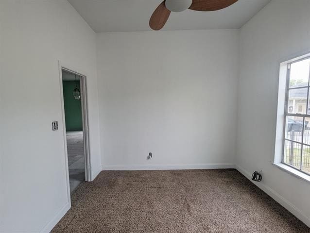 carpeted empty room featuring ceiling fan and a wealth of natural light