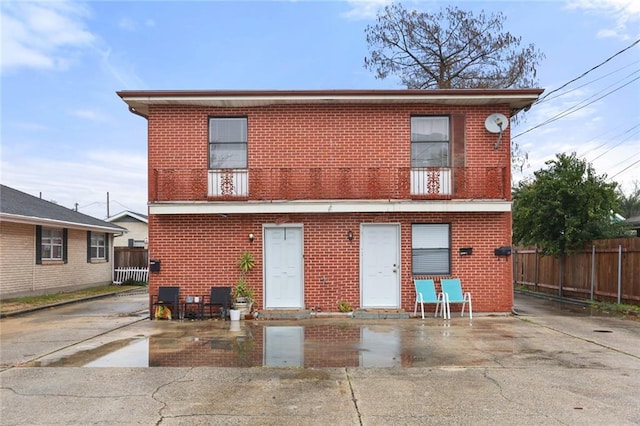 back of house featuring a balcony and a patio