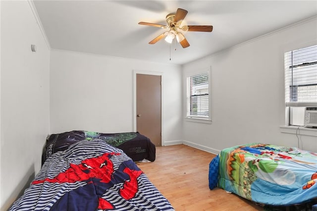 bedroom with hardwood / wood-style flooring, ceiling fan, and crown molding