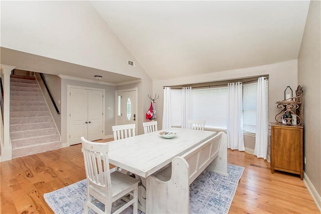 dining room with stairway, baseboards, visible vents, light wood finished floors, and a wealth of natural light