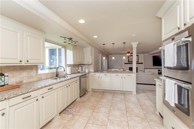 kitchen featuring a sink, tasteful backsplash, stainless steel appliances, a peninsula, and light tile patterned floors