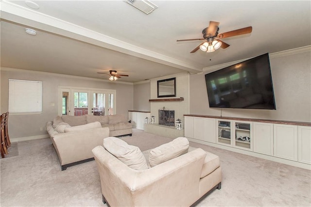 living room with visible vents, crown molding, ceiling fan, light carpet, and a fireplace