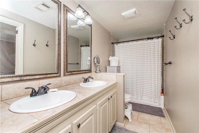 bathroom with a sink, visible vents, toilet, and tile patterned floors